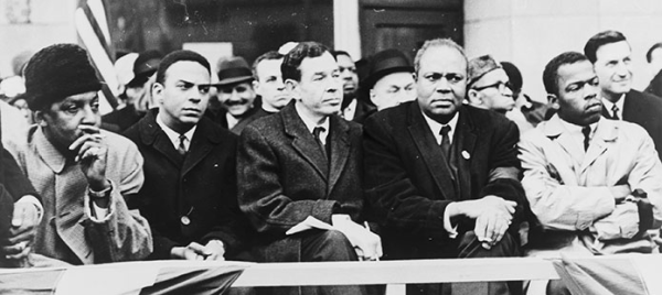 Black and white photo of Civil rights activists: Bayard Rustin, Andrew Young, Rep. William Fitts Ryan, James Farmer, and John Lewis 