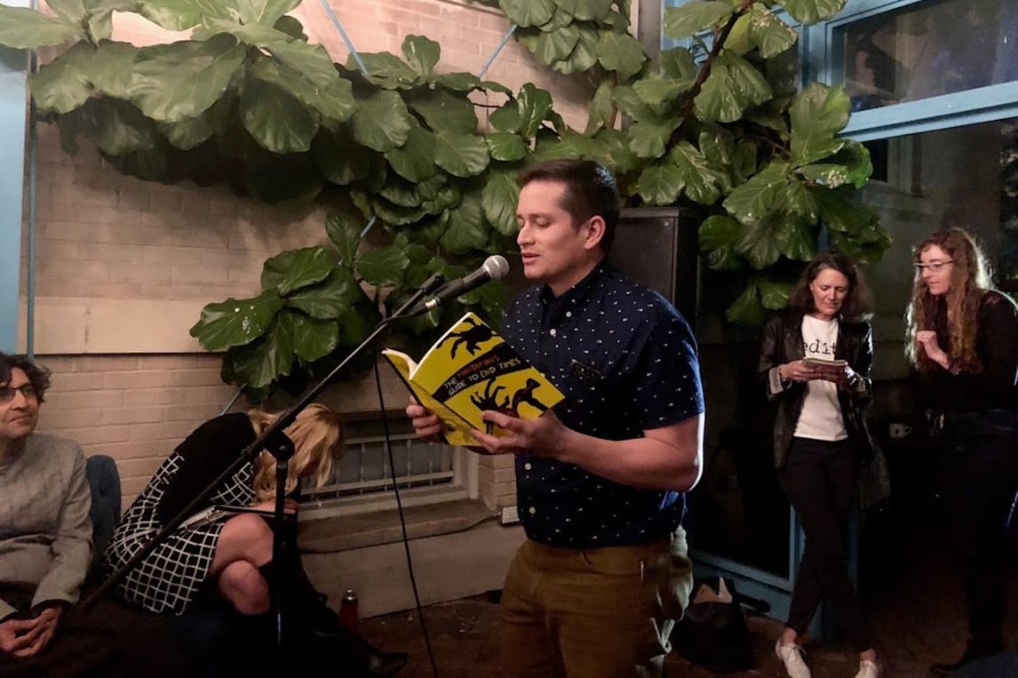 Juan Morales reading a copy of his book. 