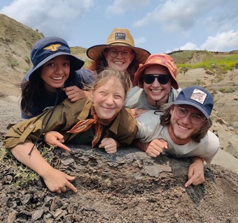 Posing with the K-Pg boundary outside of Marmarth, ND with other summer 2023 DMNS Witter interns, clockwise from top: Charlie Hite ’25, myself, Baxter Waltermire ’24, Katya Nicolayevsky ’24, and Taylor Jenkins ’26.