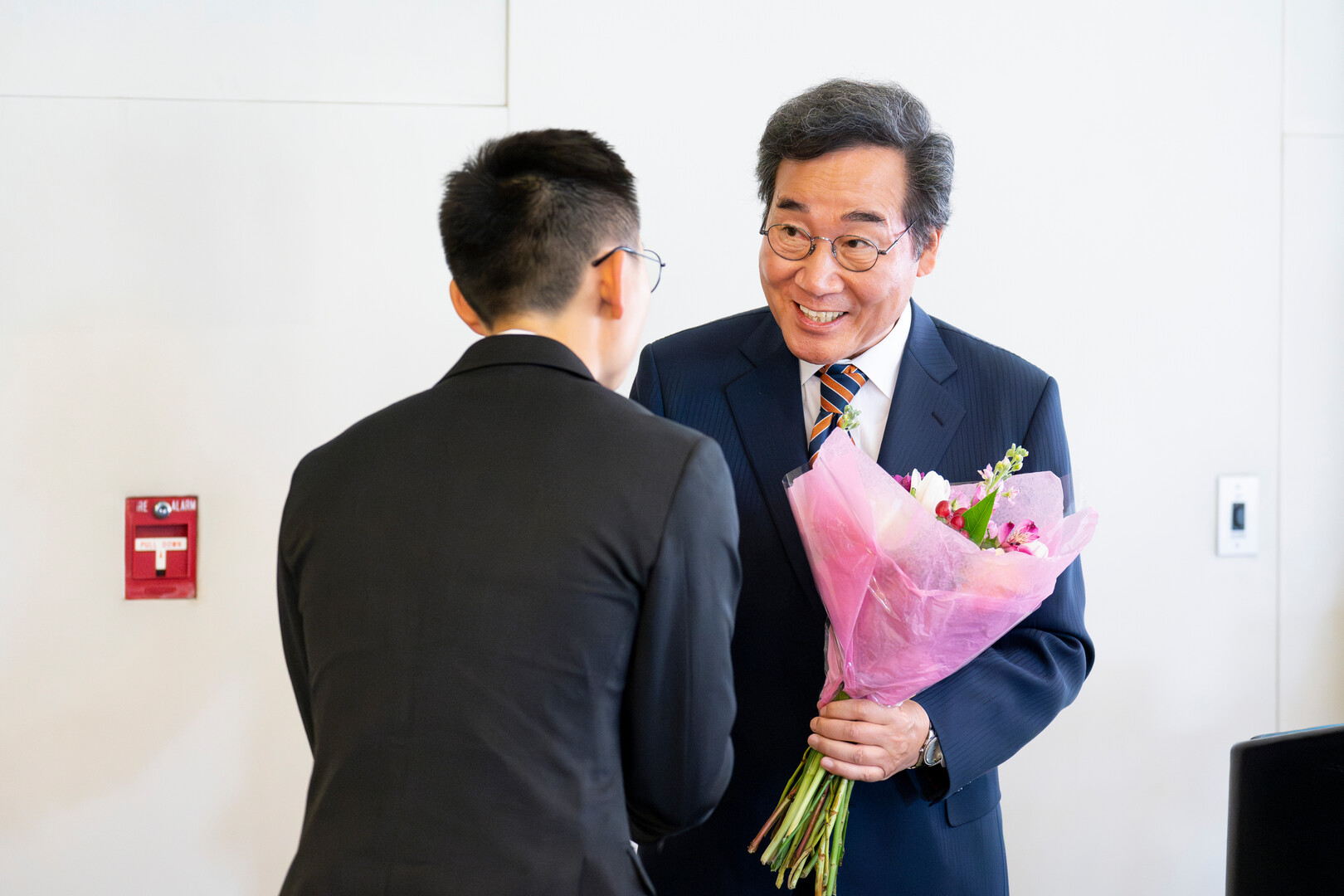 First-year student HeeYeal Lee presents a bouquet of flowers to South Korea's former prime minister, Nakyon Lee, following his speech. Photo by Lonnie Timmons III