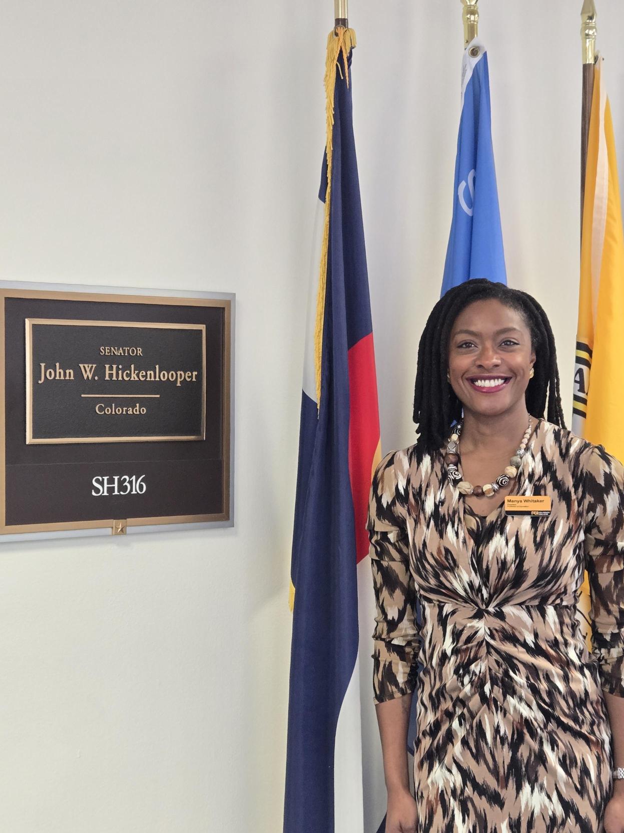 Manya in front of Hickenlooper office sign