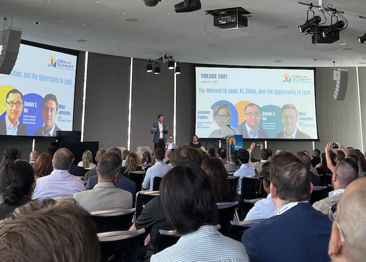 An audience watches a presentation at a conference
