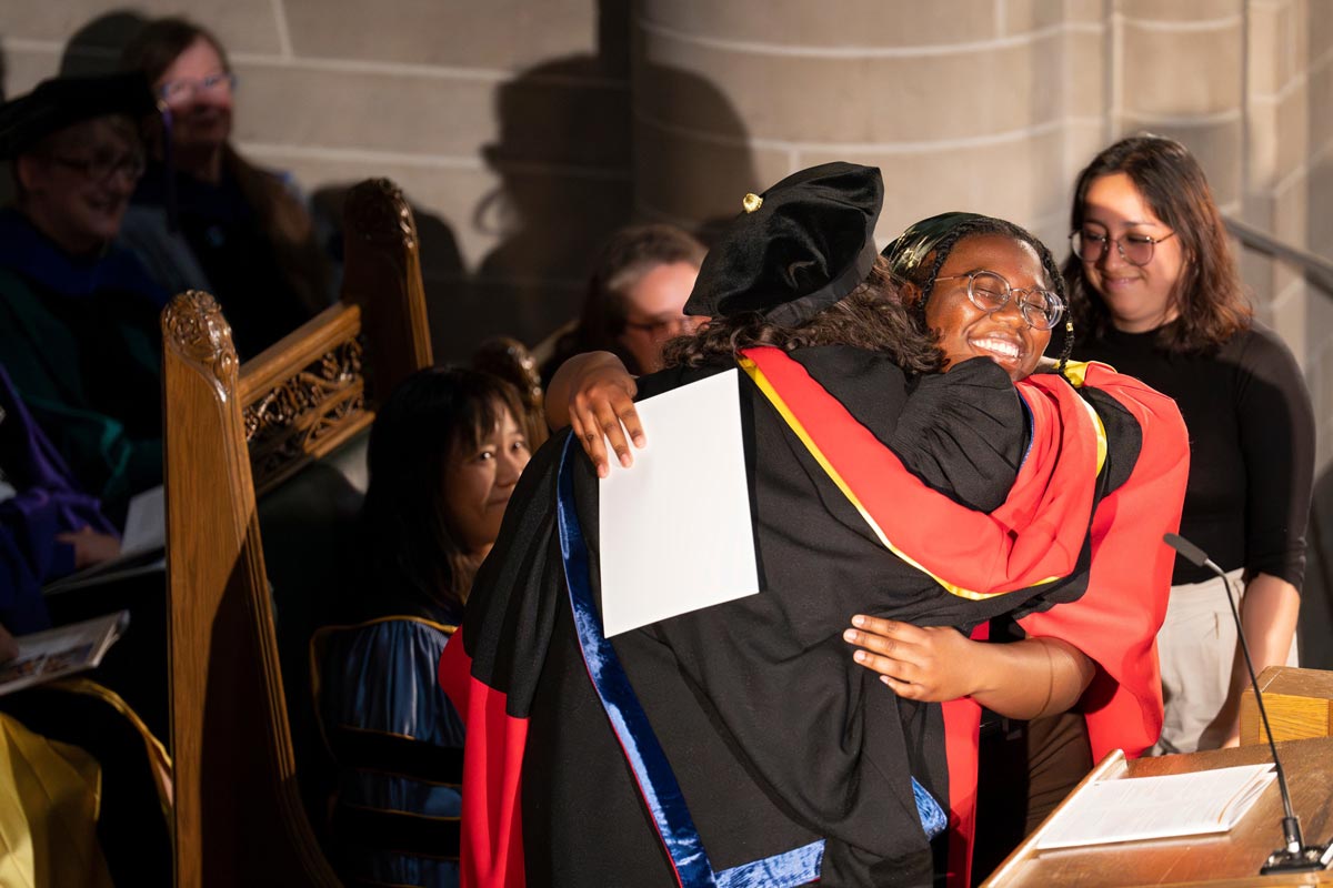 Students embracing at graduation representing equity and belonging