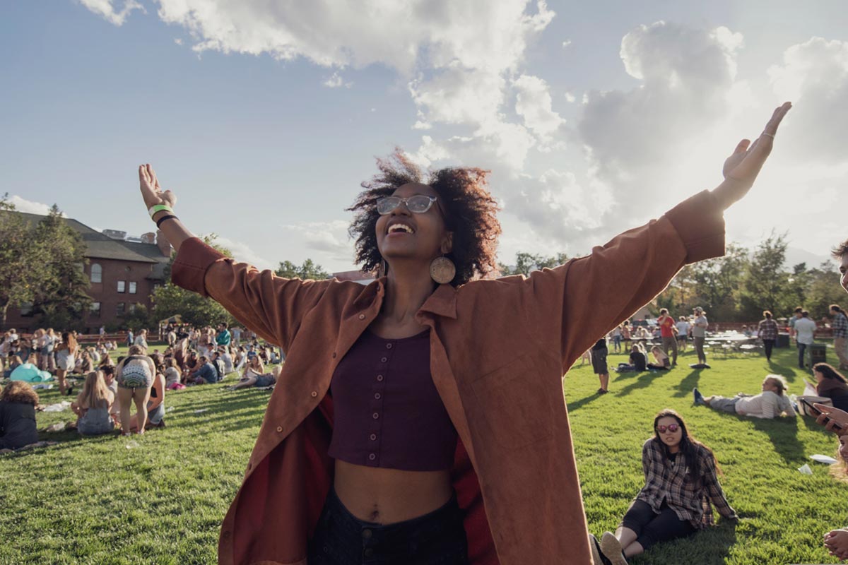 Student with arms raised celebrating representing mental health and wellness